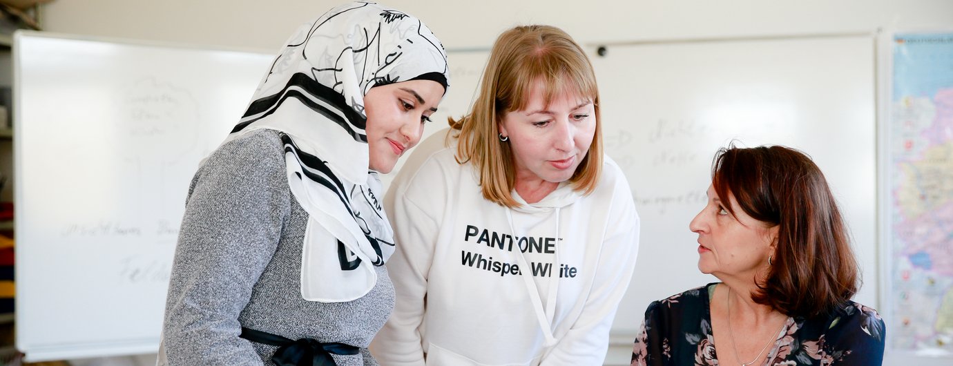 Drei Frauen stecken die Köpfe zusammen und unterhalten sich